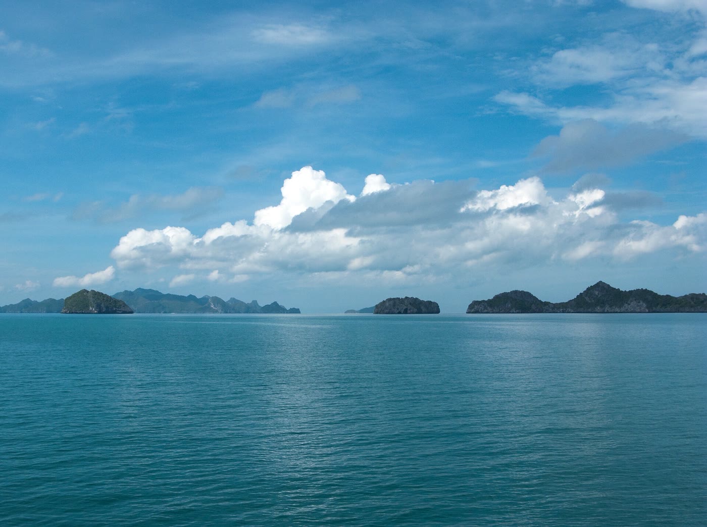 Ang Thong from the water in March 2009. The Emerald Lake is inland, and swimming there is not allowed. Photo: Vyacheslav Argenberg, Wikimedia Commons, CC BY 4.0. Limestone islands of Ang Thong under a hazy sky