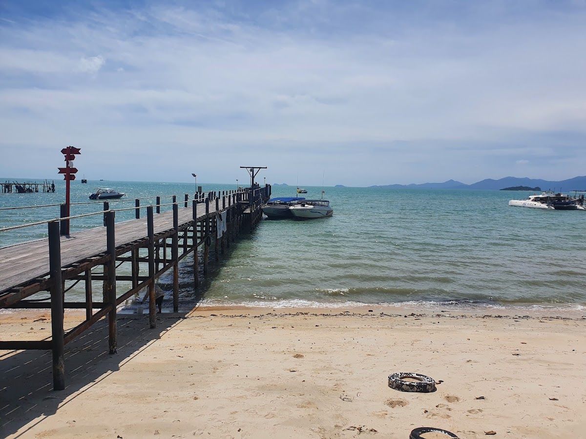 Bangrak Pier on Koh Samui's northeast coast, with speedboats moored alongside and Koh Phangan visible in the distance across the Gulf