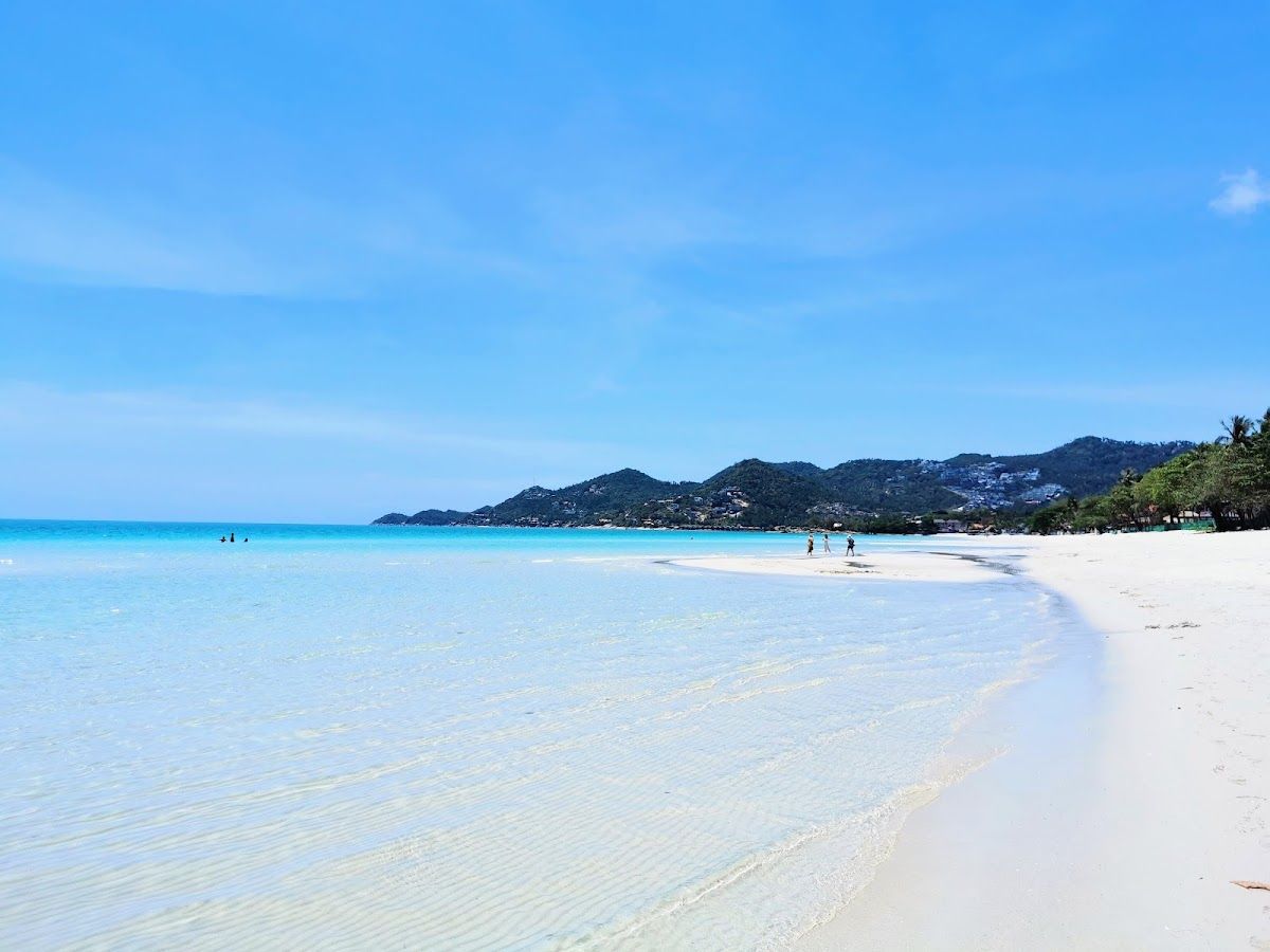 Chaweng Beach, Koh Samui — long stretch of white sand with turquoise water and green hills in the distance