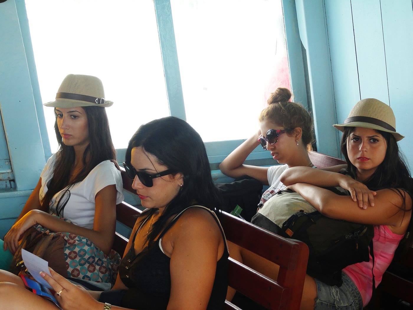 Passengers on the wooden Haadrin Queen ferry, with the Gulf and a green island beyond the rail