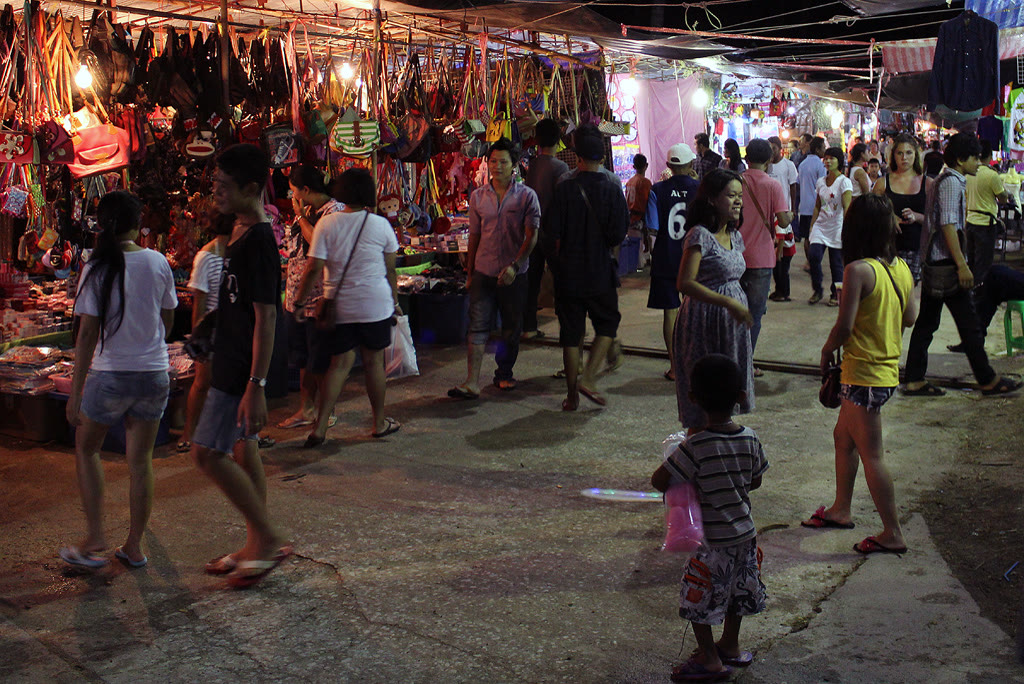 A night food stall on Koh Samui, with a cook working over a steel counter under warm lights