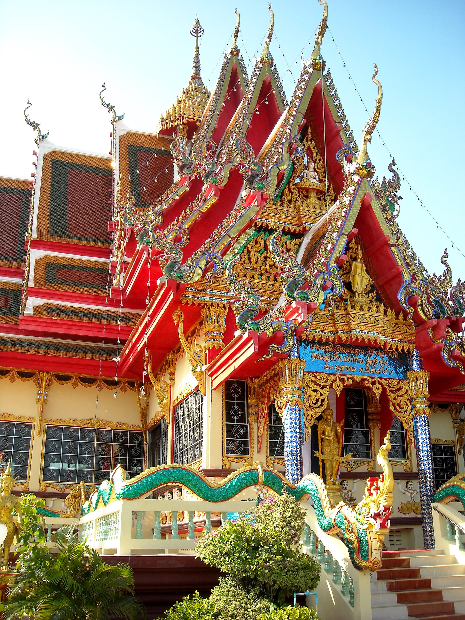 The 18-armed white Guanyin at Wat Plai Laem, seen from below against a blue sky