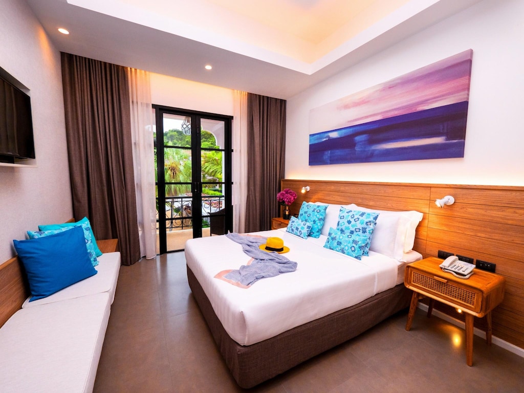 Bedroom at Absolute Sanctuary with a large bed, white linens and a window toward the sea