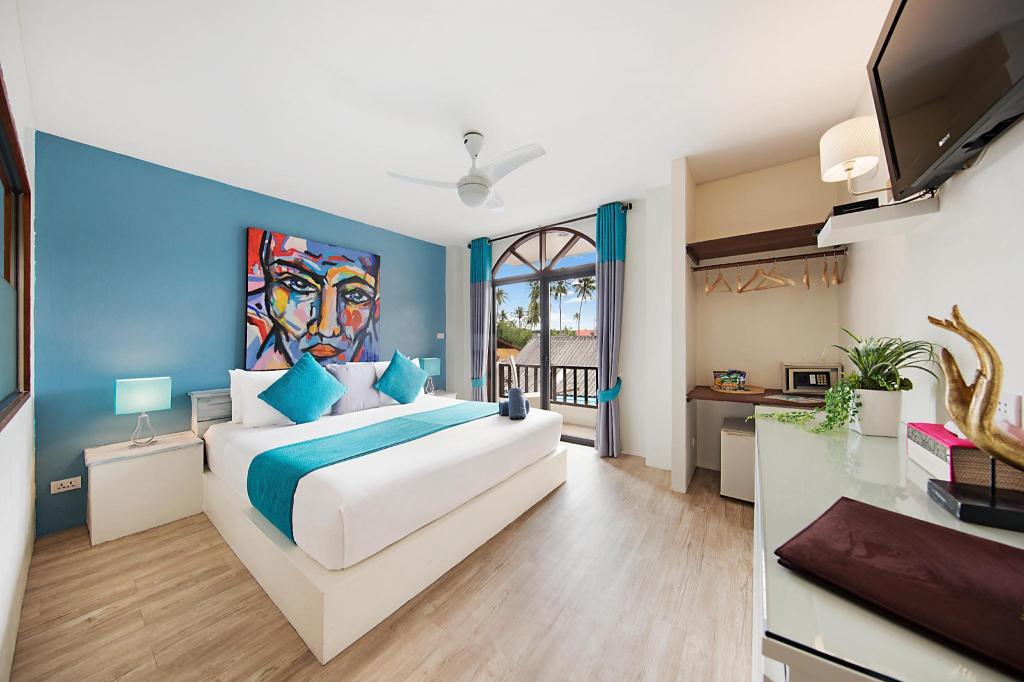 Bedroom at Hacienda Fisherman's Village with a large bed, wooden headboard and glass doors to a balcony