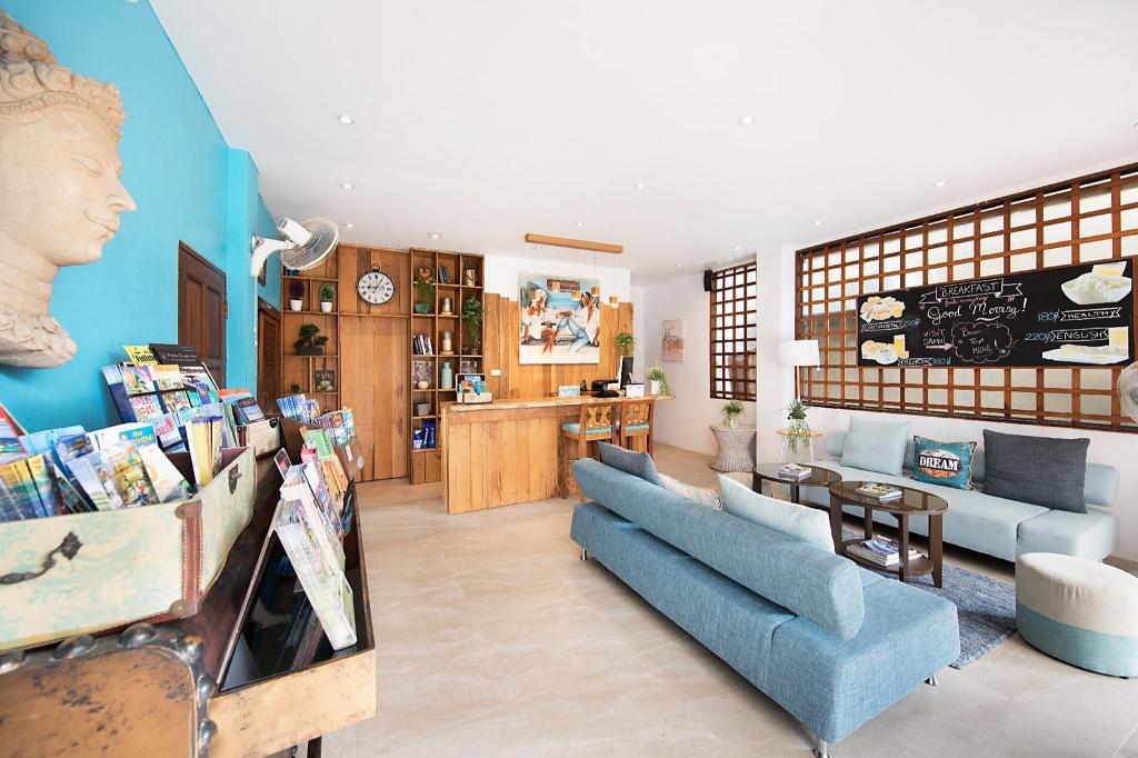 Reception lobby at Hacienda Fisherman's Village with a wooden counter, white sofas and a tiled floor