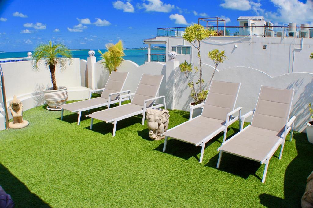 Pool deck at Hacienda Fisherman's Village with white daybeds, wooden umbrellas and a thatched-roof building