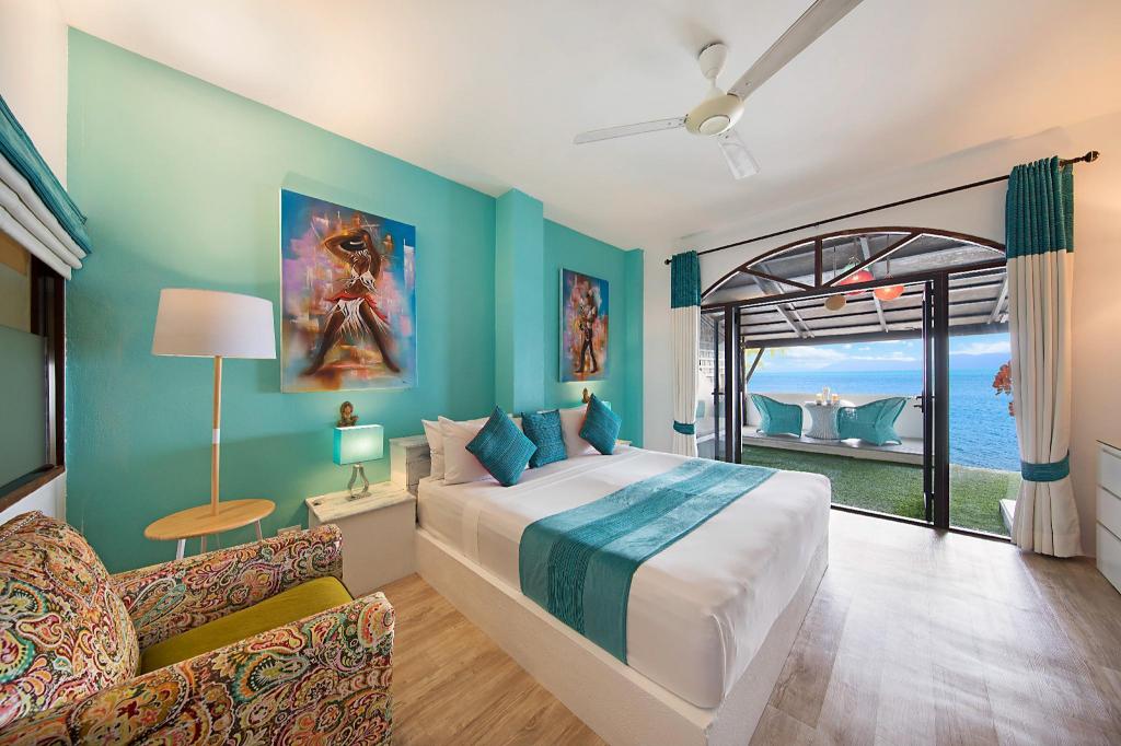 Seating area in a suite at Hacienda Fisherman's Village, with a sofa, a low table and windows toward the water
