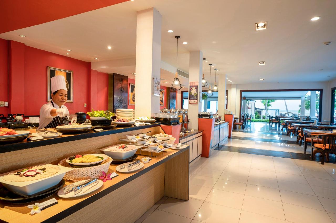 Restaurant at The Briza Beach Resort, with set tables, wooden chairs and a tiled floor