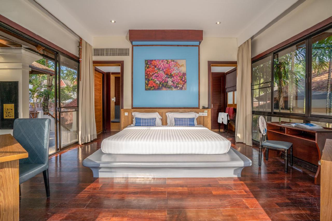 Bedroom in a villa at The Briza Beach Resort, with a large bed, white linens and a sofa