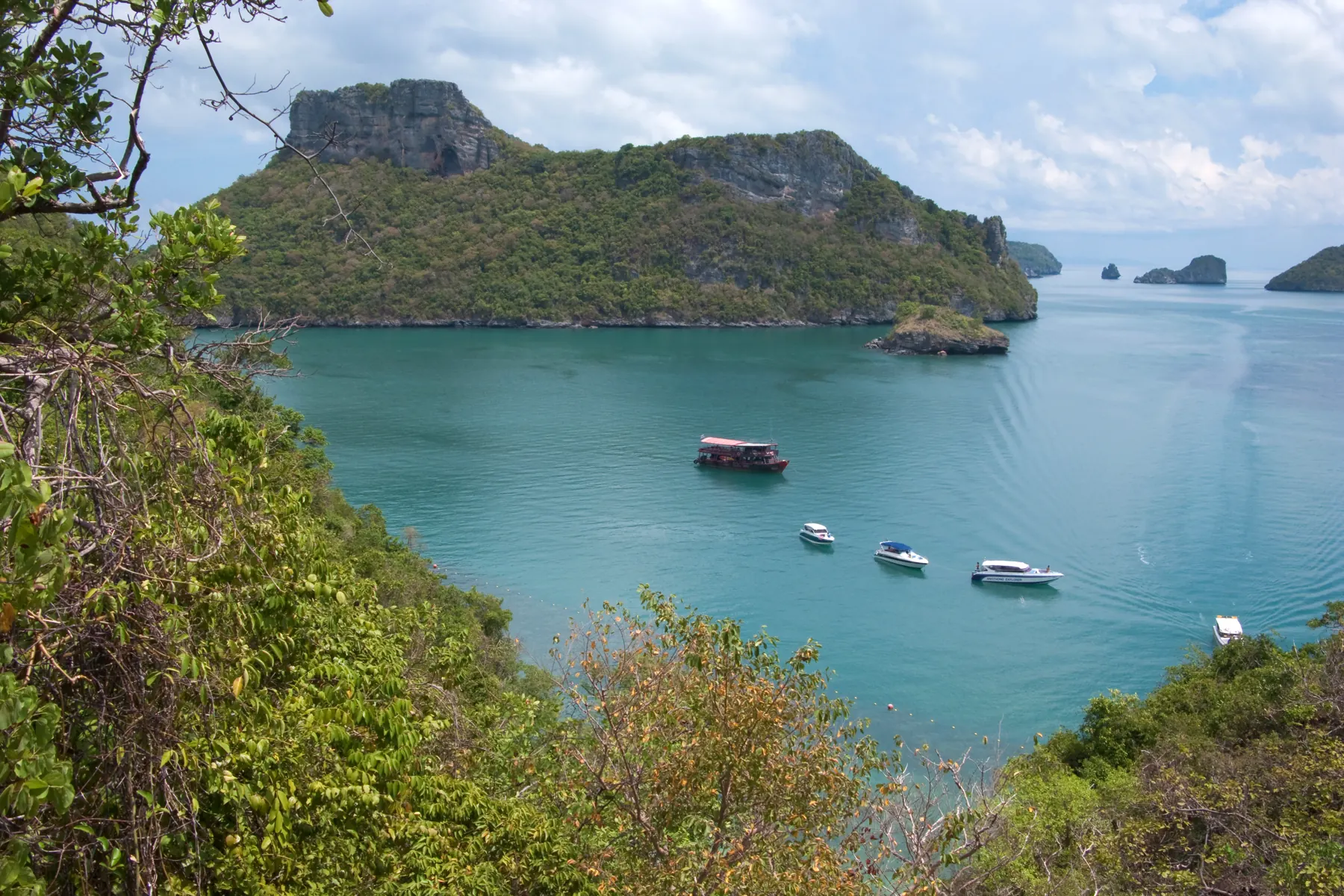 A turquoise bay in Mu Ko Ang Thong marine park, with shallow water, a pale beach and limestone cliffs
