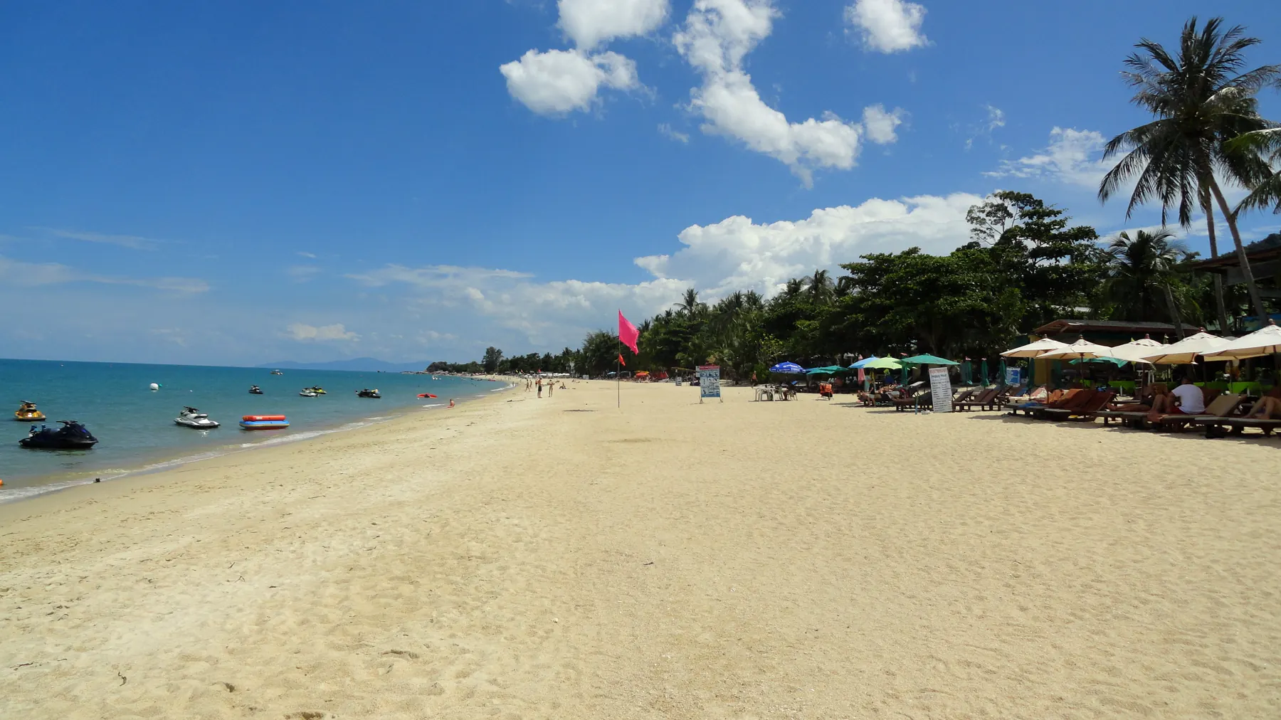 Lamai Beach, Koh Samui, in warm light, with long-tail boats on the sand and a rocky headland